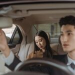 Elegant Asian business professionals in car showcasing modern interior design and style.