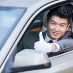 Chauffeur doing thumbs up inside car
